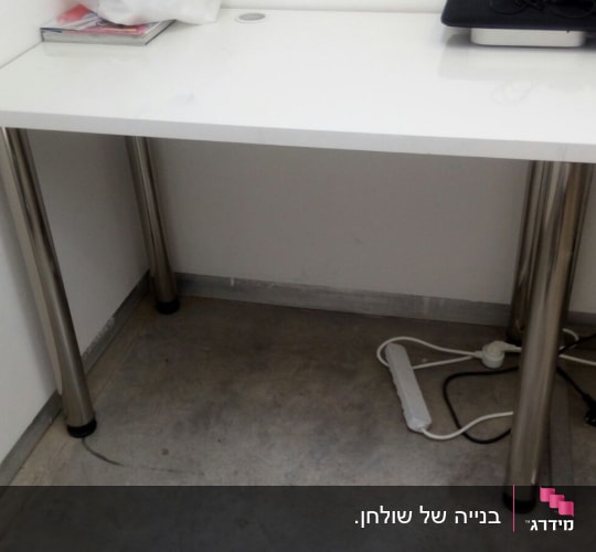 שולחן עם רגלי מתכת על רצפת בטון